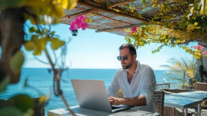 Man using laptop at table near beach